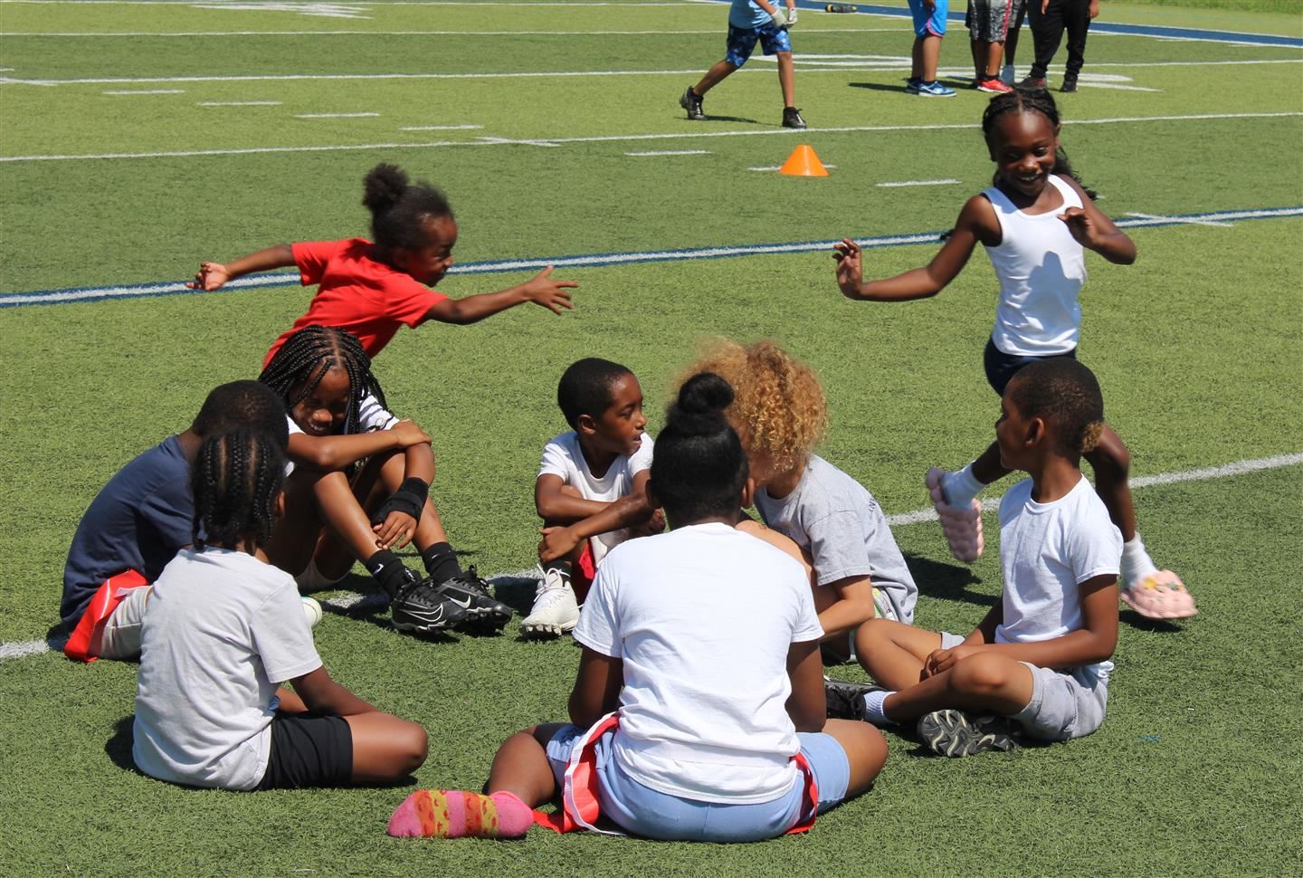  Students play duck, duck, goose on a football field